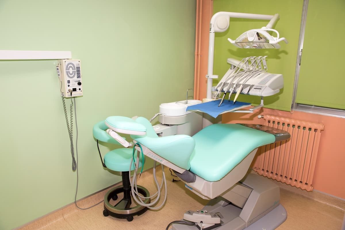Sala de tratamiento dental con sillón verde agua en Chantada